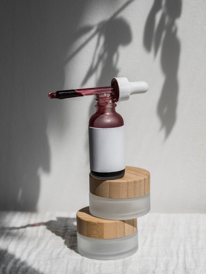Still life of a minimalist cosmetic dropper bottle with shadow play, perfect for product mockups.
